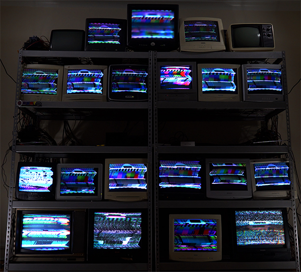 photo of a stack of 19 CRT monitors showing a PAL test pattern being manipulated by electromagnets generated by the CRT Flux Phaser software