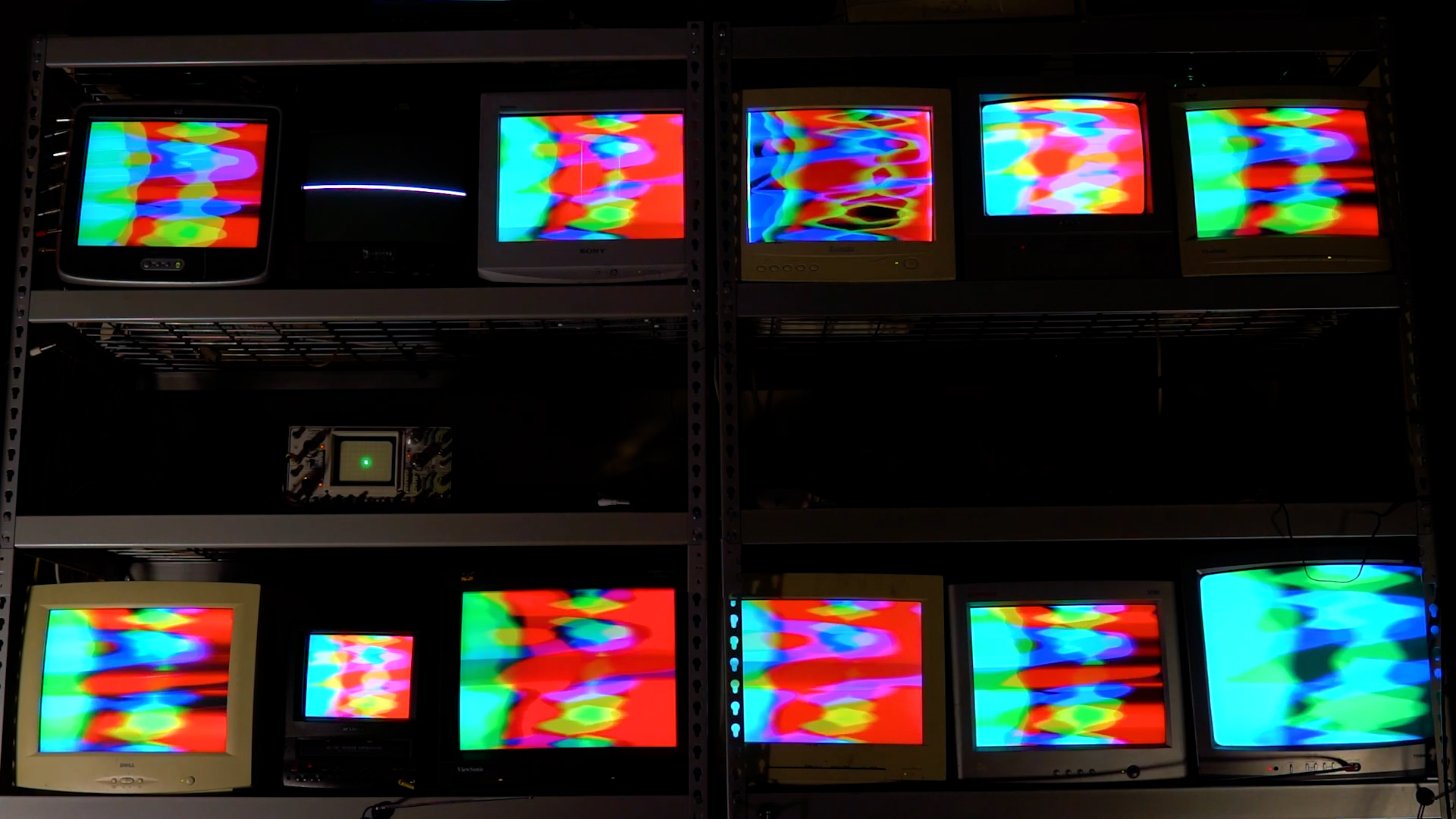 13 cathode ray tubes showing bright video synthesis colors