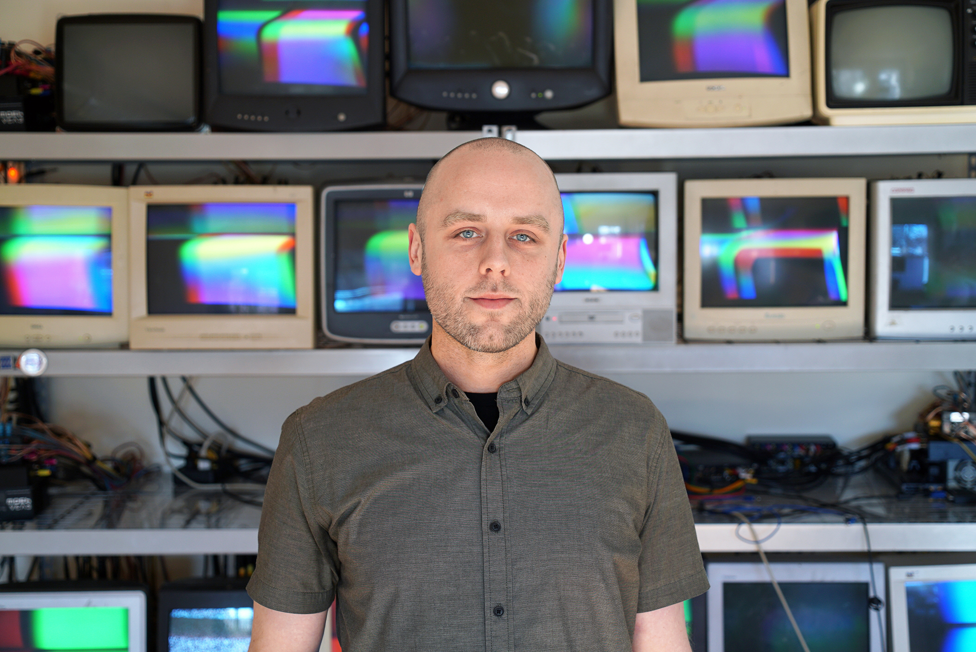 Portrait of James Connolly standing in front of a stack of CRT monitors