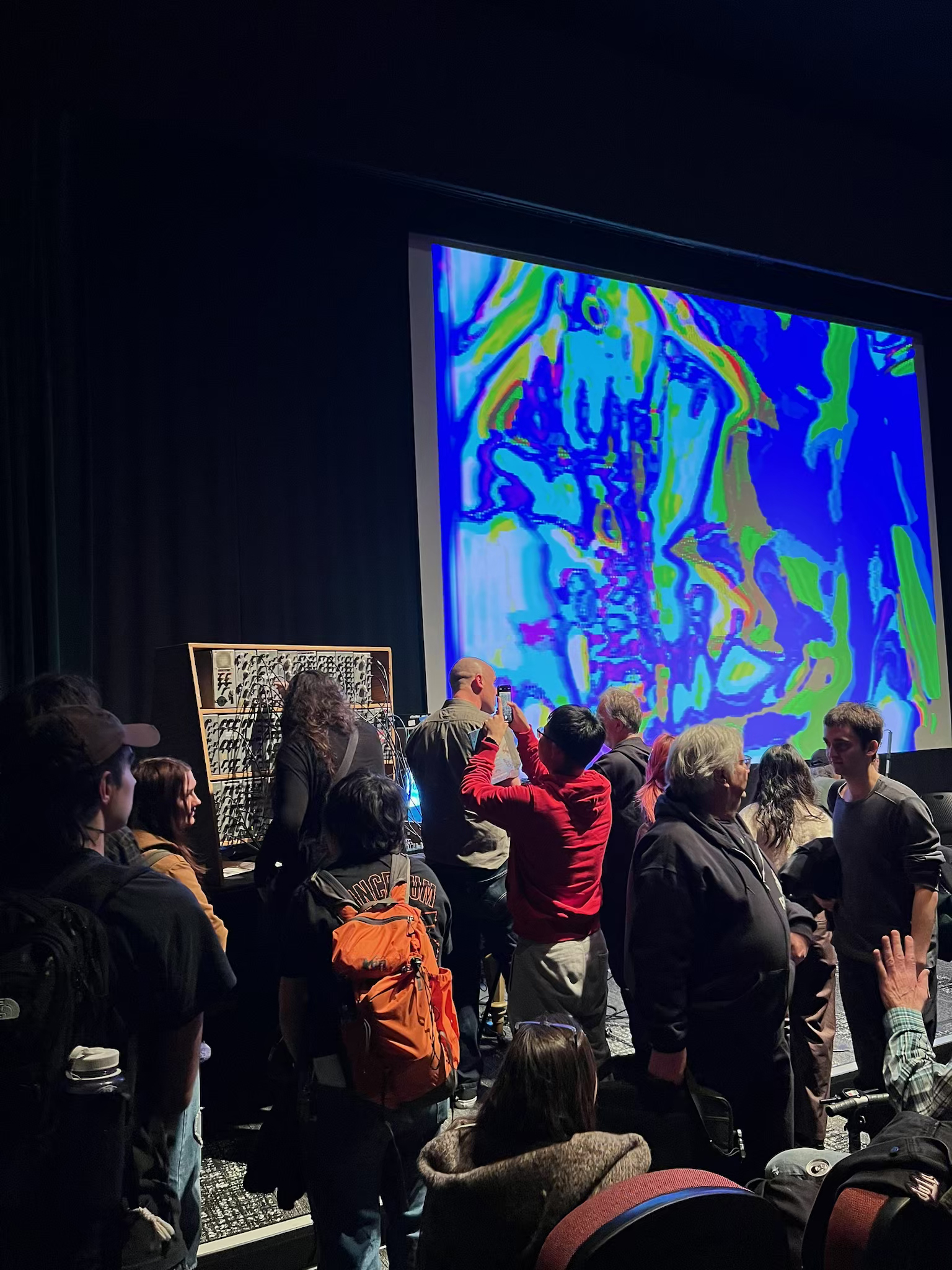 James Connolly speaking with people on stage at the Gene Siskel Film Center as audience members interact with the historic Sandin Image Processor
